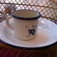 Emaille Tasse creme mit blauen Blümchen und Teller weiss