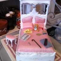 Bett rosa, dekoriert, mit Hocker
